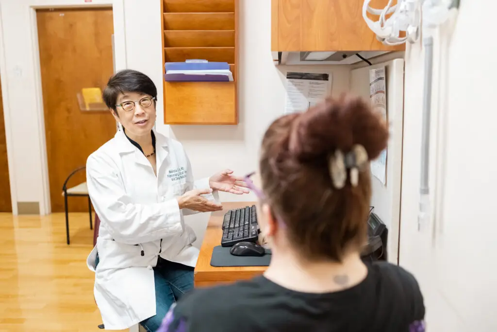 Doctor speaking with hands with patient in exam room