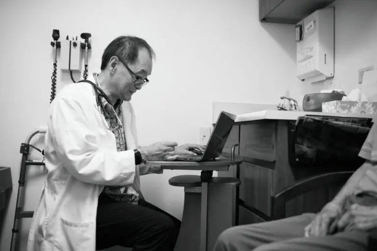 Doctor not helping patient and staring at laptop screen